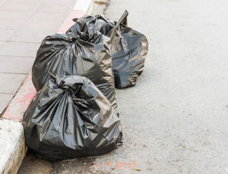 Worker securing a skip for collection in a residential street