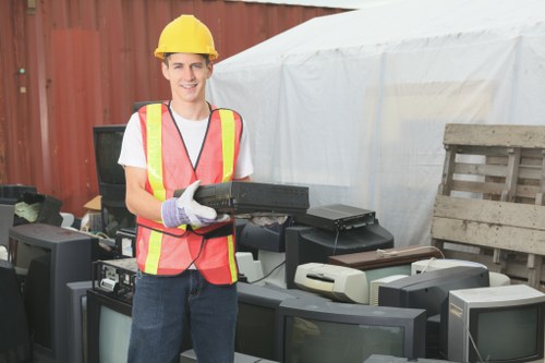 Technician assessing site access for skip delivery near a Thamesmead property
